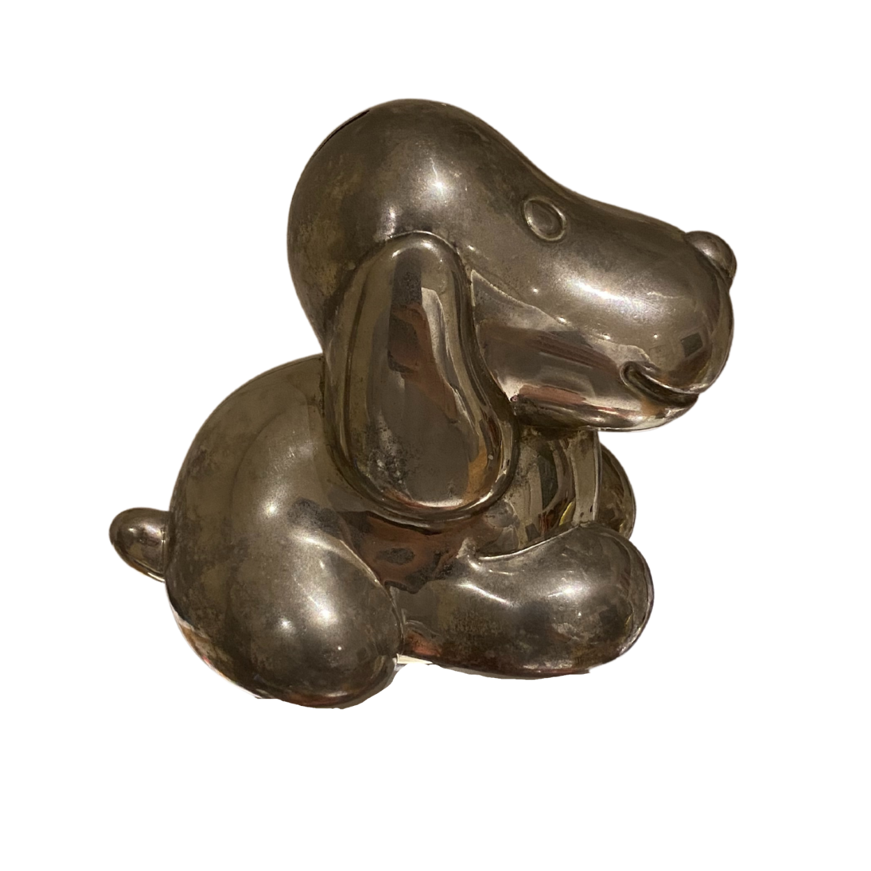 A photo of a small piggy bank in the shape of a hound, made of brass facing right.